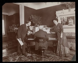 Clara De Regand pointing to a score while a man plays the piano